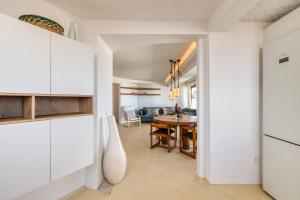 法马拉Villa Taguluche Famara的厨房以及带白色橱柜和桌子的用餐室。