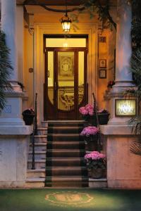 罗马法恩斯酒店的一座带楼梯和鲜花的建筑的前门