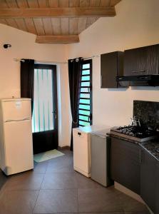 圣若瑟Les 3 Soleils的厨房配有白色冰箱和炉灶。