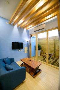 马公夏海民宿的客厅配有蓝色的沙发和桌子