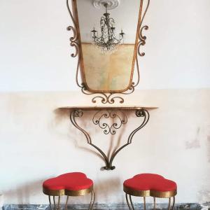 热那亚Casa Ramé的墙上镜子下面的两张红色凳子