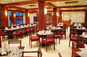 霍尼亚拉所罗门其塔诺曼达纳酒店的用餐室配有桌子和红色椅子以及桌上桌