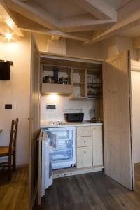 圣米凯莱亚拉迪杰阿菲塔卡米莉拉费拉塔旅馆的厨房配有白色橱柜和冰箱。