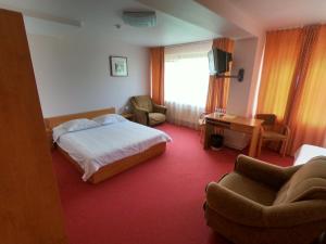 马多纳马多纳酒店的一间卧室配有一张床、一张沙发和一把椅子