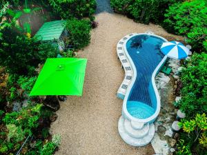 蔻立The Mouth Resort - SHA Extra Plus的享有带绿桌和遮阳伞的游泳池的顶部景致