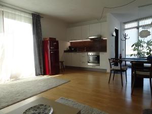 Ampass Unterdorf2-Zimmer Apartment Inntalblick的厨房配有桌子和红色冰箱