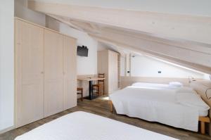 圣米凯莱亚拉迪杰阿菲塔卡米莉拉费拉塔旅馆的卧室配有一张白色大床和一张书桌