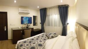 瓦迪穆萨Petra Heart Hotel的一间卧室配有一张床、一张书桌和一台电视