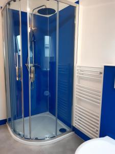 阿尔特基克loft studio avec charme et authenticité的浴室设有玻璃淋浴间,拥有蓝色的墙壁