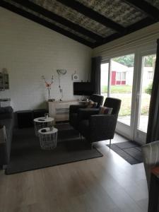 辛佩尔费尔德Rustige, gelijkvloerse vakantiewoning met 2 slaapkamers in Simpelveld, Zuid-Limburg的客厅配有沙发、椅子和桌子