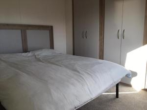 迪姆彻奇Gold Plus Caravan的卧室配有白色的床和衣柜。