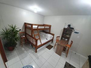 因比图巴Kitnet Praia da Vila Imbituba的客房设有双层床和桌椅。