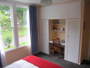 HalcombeThyme Out Estate的一间卧室配有书桌、床和窗户。