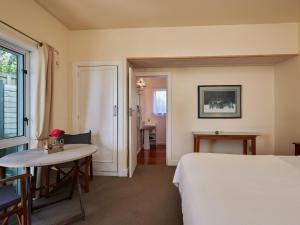 凯库拉Lemon Tree Lodge的酒店客房配有一张床铺和一张桌子。