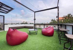 曼谷LOBSUEK Hostel หลบศึก โฮสเทล的屋顶庭院设有桌椅和草地。