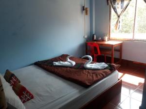 NongkhiawLamorn Guesthouse的一张床上有两只天鹅在房间里