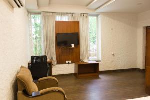 海得拉巴Mrugavani Resort & Spa的客厅配有平面电视和椅子