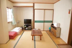 京都京都城市托米瑞奇住宿旅馆的客厅配有桌子和电视