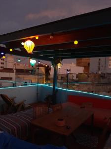 阿尔么丽亚La Pita Guesthouse的屋顶上带桌子和灯的天井