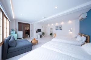 东京STAY ARI Arakicho的一间卧室配有两张床和蓝色的沙发