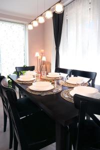 布达厄尔什Townhouse on Budapest border的餐桌,配有黑色椅子和白色盘子