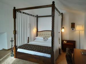 奥拉维察康多尔酒店的一间卧室配有一张四柱床和天蓬