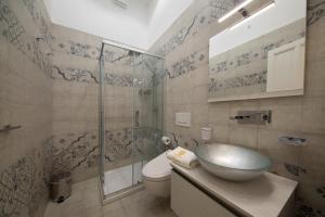 雷妮Hotel L'Ariana ISOLE EOLIE - UNA Esperienze的一间带水槽和玻璃淋浴的浴室