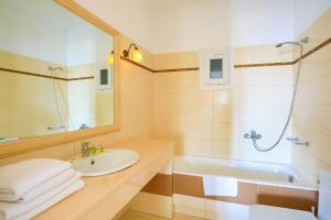 帕瑞加梅根诺斯公寓酒店的一间带水槽、浴缸和镜子的浴室