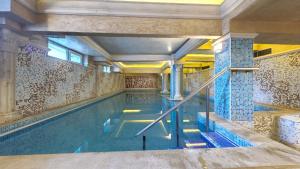 韦林格勒Balneo & SPA Hotel Aura的一座带瓷砖墙的建筑中的游泳池
