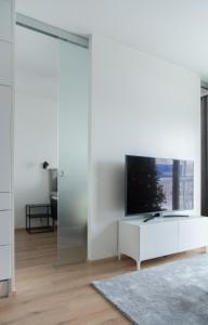 罗瓦涅米Lapland Arctic Apartments的一间客厅,在白色的墙上配有电视
