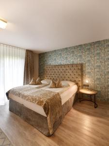 亚琛卓越艺术酒店的一间卧室配有一张大床和一张桌子