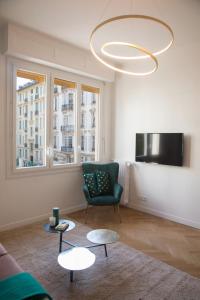 尼斯Beautiful apartment in the heart of Nice的客厅配有沙发、两张桌子和吊灯