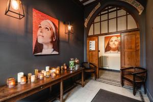 根特Hotel Monasterium PoortAckere Ghent的一间设有一张桌子的房间,墙上挂有蜡烛和肖像