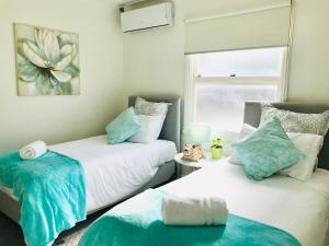 墨尔本Melbourne Inner City Holiday Home Near CBD & Flemington的一间卧室配有两张蓝色和白色的床