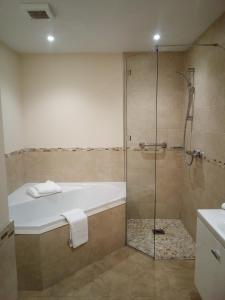 黑德科恩肯特原野高尔夫酒店的设有带浴缸和淋浴的浴室。