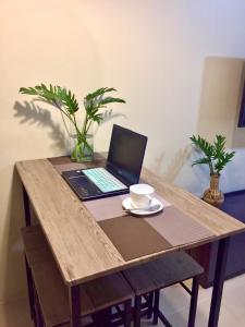 宿务Cozy studio in Cebu IT Park的一张带咖啡的木桌上的笔记本电脑