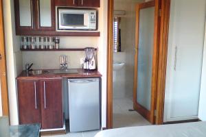 巴利托Jakita's Guest house的一间带水槽和微波炉的小厨房