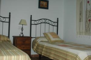 扎霍拉茉莉花度假屋的一间卧室配有两张床、一盏灯和梳妆台。