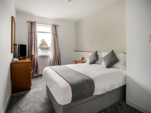 艾尔OYO Glenpark Hotel, Ayr Central的一间卧室设有一张大床和一个窗户。