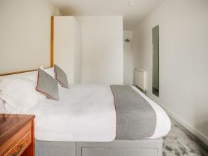 艾尔OYO Glenpark Hotel, Ayr Central的卧室配有白色大床和木制梳妆台