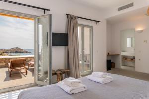 普拉迪斯亚罗斯Trinity Mykonos - Villa & Beachfront Boutique Hotel的一间卧室配有一张床,享有海景