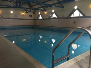 伯恩茅斯卡林顿房屋酒店的大楼内带灯光的游泳池