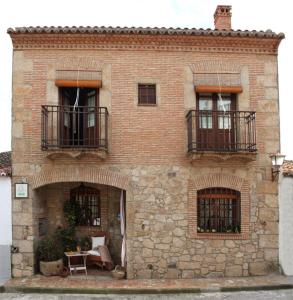 Aldea de Trujillo卡萨厄尔特纳多乡村民宿的砖砌建筑,设有两个阳台和桌子