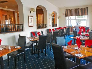 伯恩茅斯卡林顿房屋酒店的餐厅配有桌椅和红色餐巾