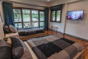 罗勇F5 3 Bed Rooms Beach house, full kitchen的一间卧室配有两张床和一台平面电视