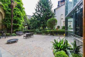 贝加莫Altana Bergamo Home的一个带长椅和桌子的庭院和一座建筑