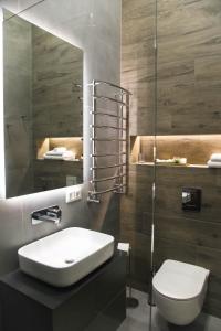 切尔诺夫策Apart Hotel на Трояндовой的一间带水槽、卫生间和镜子的浴室