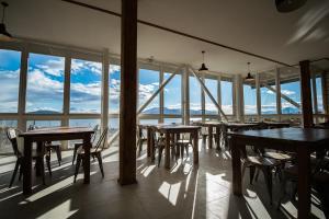 纳塔列斯港Best Western Patagonia的餐厅设有桌椅和大窗户。