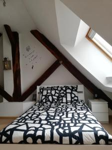 蒙贝利亚尔Atelier des Poèmes.的一间位于阁楼的卧室,配有黑白床