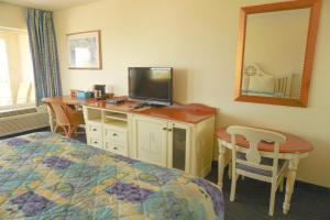 圣奥古斯丁圣奥古斯丁海景旅馆的一间卧室配有一张床和一张书桌及电视